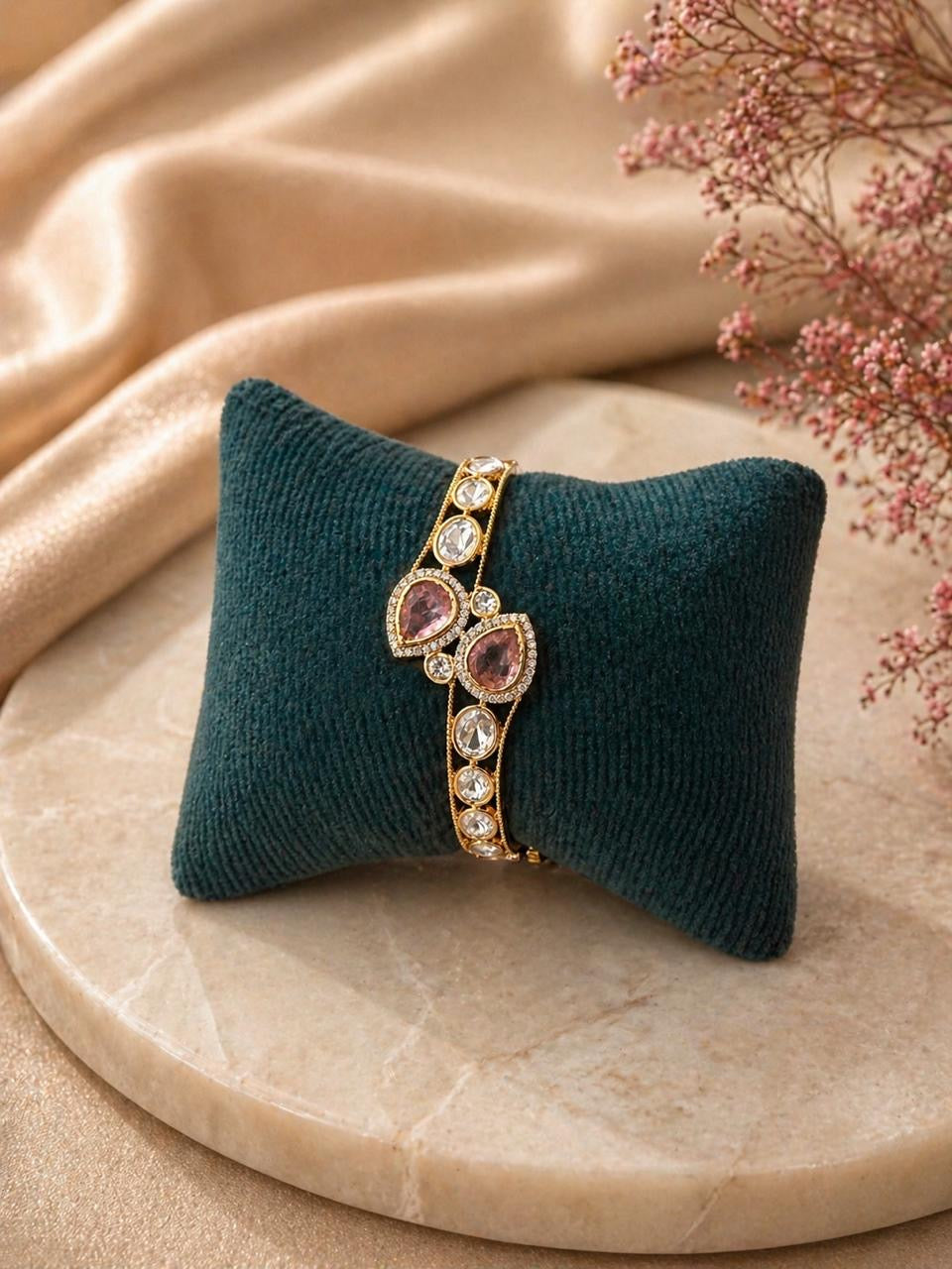 Gold bracelet with pink teardrop stones and round crystal detailing