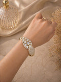 Gold statement kada bracelet with polki stones and carved centerpiece design