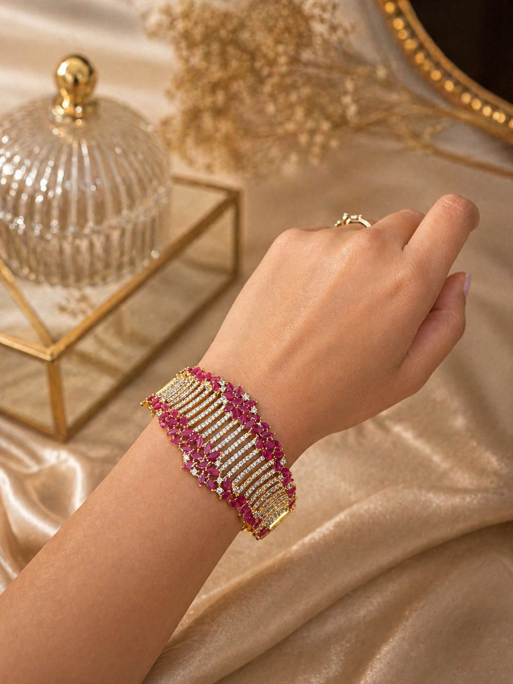 Gold statement bracelet with ruby stones and crystal detailing in a bold design