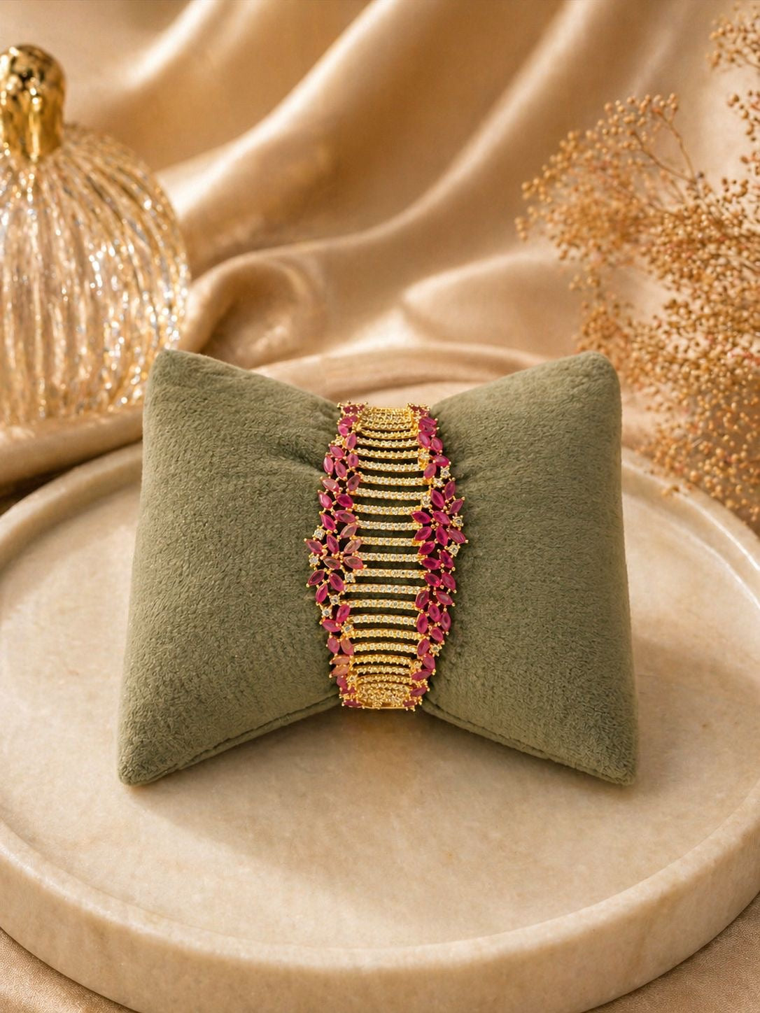 Gold statement bracelet with ruby stones and crystal detailing in a bold design