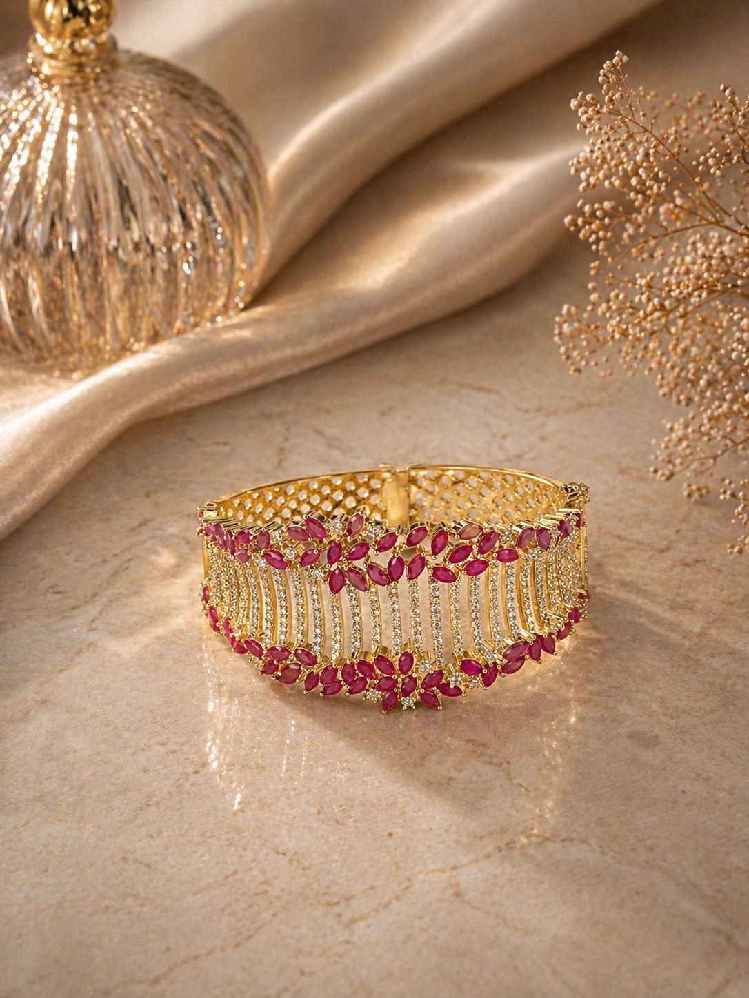 Gold statement bracelet with ruby stones and crystal detailing in a bold design