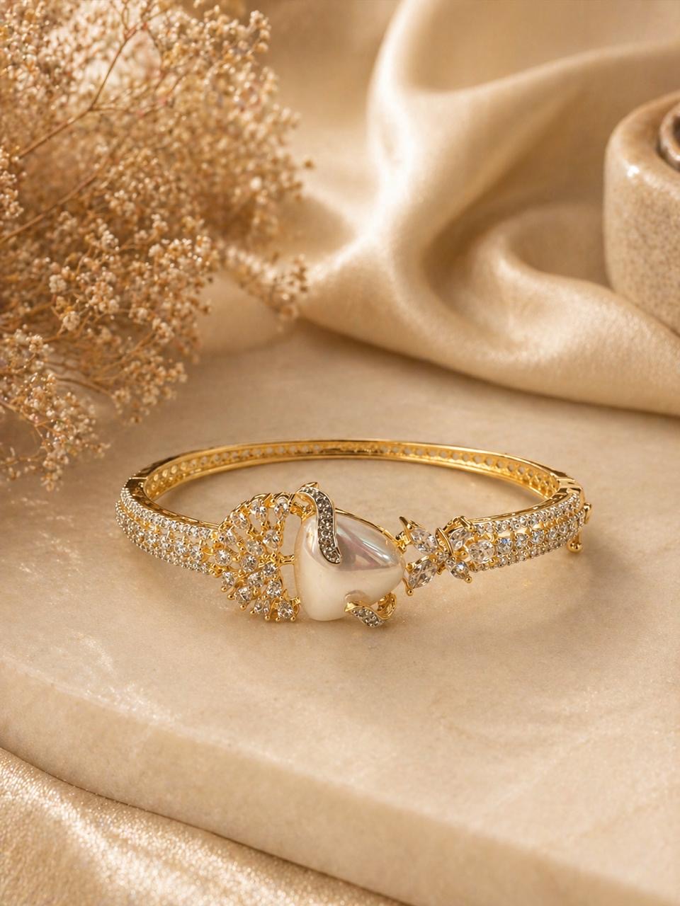 Gold swan bracelet with pearl center and crystal detailing in elegant design