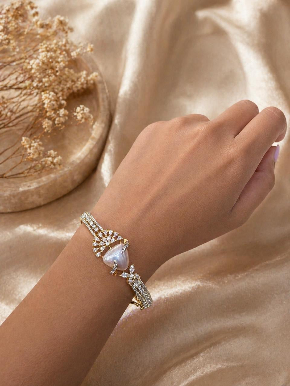Gold swan bracelet with pearl center and crystal detailing in elegant design