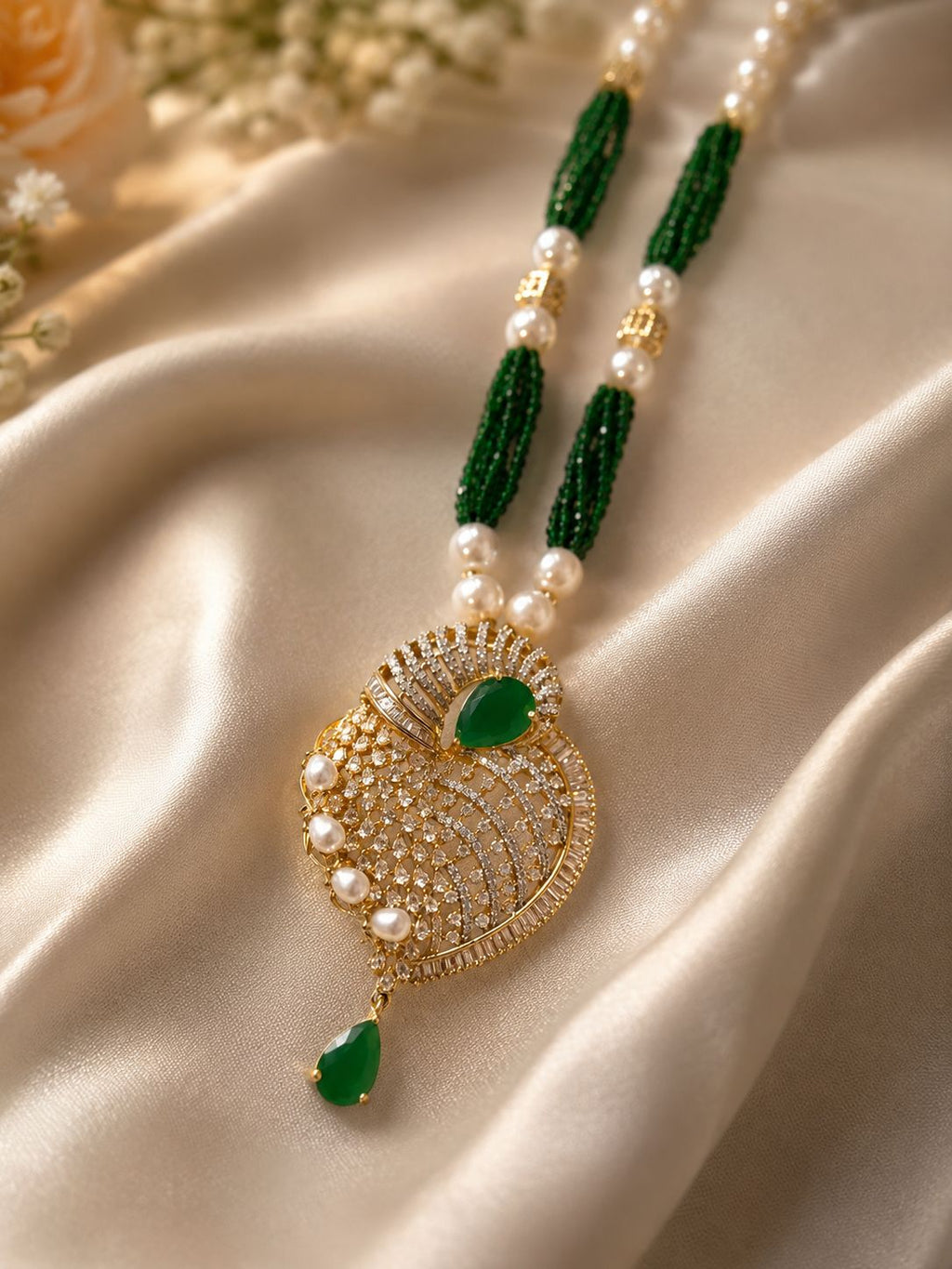 green stone pearl pendant necklace set with matching earrings displayed on pink stand