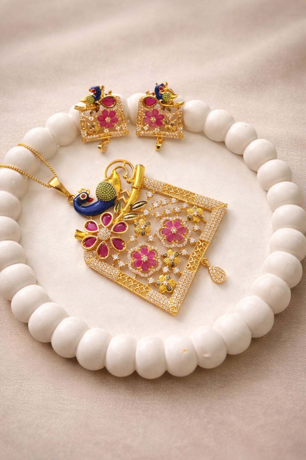 Gold finish peacock pendant set with floral design for festive and traditional wear