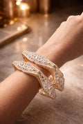 Real gold finish diamond look serpentine design bangles set worn on hand for wedding and festive wear